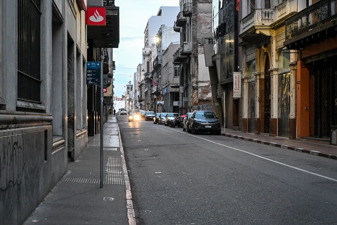 Sleek electric supercar charging on a modern Montevideo street at dusk