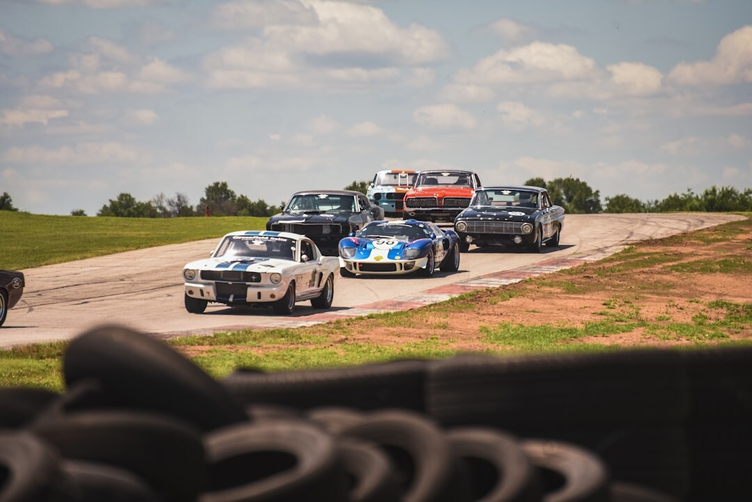 Line of classic rally cars parked along a colonial cobblestone street in Colonia