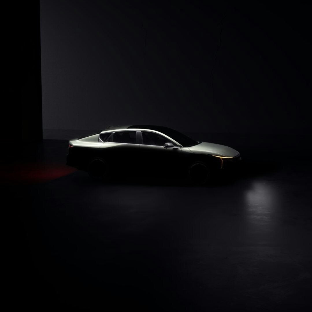 Matte gold hypercar photographed in a dark studio with dramatic lighting